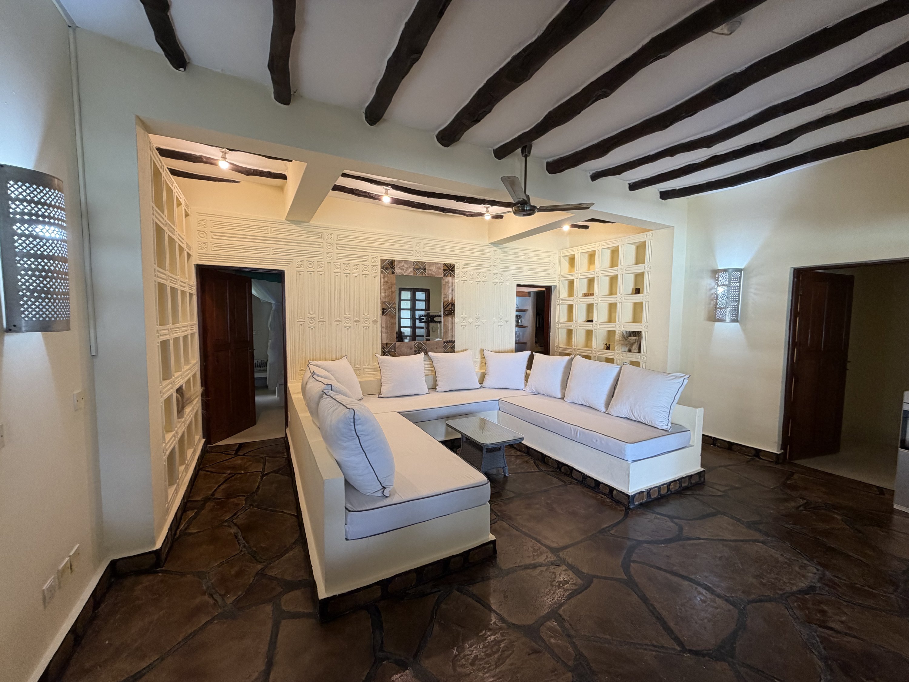 Open-plan lounge under dark hardwood beams
